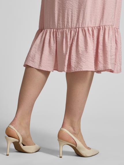 Vrouwenmodel draagt midirok uit viscosemix met volantzoom van Christian Berg Woman, lichtroze, lichte A-lijn, detailopname onderbenen.