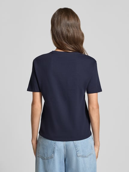 Frauenmodel trägt Regular Fit T-Shirt aus reiner Baumwolle mit Blumen-Applikation von Christian Berg Woman, dunkelblau, Kurzarm, Rückenlänge 54 cm, Ganzkörperansicht Rückansicht.
