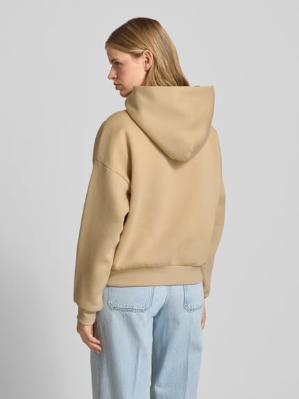 Frauenmodel trägt Hoodie mit Motiv-Stitching und Känguru-Tasche von REVIEW aus Baumwoll-Mix im Regular-Fit, Rückansicht.
