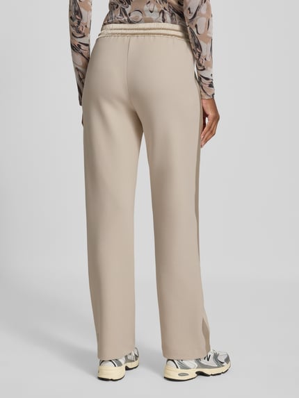 Frauenmodel trägt Sweatpants mit elastischem Bund und Tunnelzug von Marc Cain in Beige, Baumwoll-Mix, Relaxed Fit, Ganzkörperansicht Rückansicht.