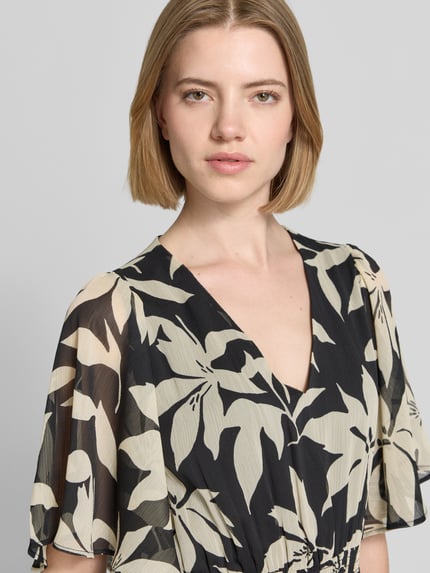 Frauenmodel trägt Tailliertes Chiffonkleid mit Allover-Muster von s.Oliver RED LABEL, grafisches und florales Muster, Chiffon, Crêpe, Nahaufnahme Oberkörper.