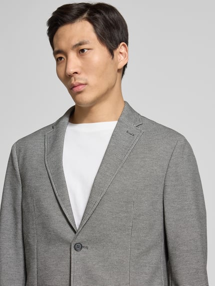 Mannenmodel draagt Slim Fit 2-Knopf-Sakko mit Strukturmuster van Pierre Cardin, grijs met fijn structuurpatroon, reverskraag, opgestikte zakken, materiaal-mix met stretch, Nahaufnahme bovenlichaam.