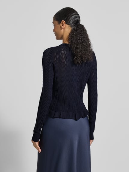 Modelka nosi Strickjacke mit Rundhalsausschnitt und Wellensaum von Christian Berg Woman Selection, granatowy, krój regular fit, długość tyłu 53 cm, rękawy 67 cm, widok całej sylwetki od tyłu.