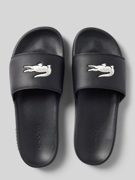 Produktfoto, Badeschuhe mit Logo Print Modell 'SERVE SLIDE' von Lacoste, czarny, zaokrąglony nosek, płaski obcas, strukturalna podeszwa, jednolity kolor, otwarty fason