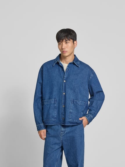 Männermodel draagt vrijetijdsoverhemd in denimlook van WON HUNDRED, puur katoen, relaxed fit, opgestikte zakken, knoopsluiting, ganzekörperansicht van voren.