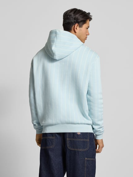 Männermodel draagt Hoodie mit Kapuze van KARL KANI in lichtblauw met witte strepen, katoenmix, los vallend, rugaanzicht.