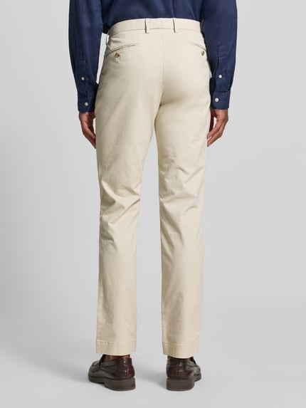 Männermodel trägt Slim Fit Chino aus Baumwoll-Mix Modell 'GREENWICH' von Polo Ralph Lauren, beżowe, Ganzkörperansicht Rückansicht.
