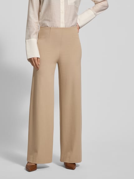 Frauenmodel trägt Stoffhose mit Gesäßtaschen Modell 'KIMBERLEY' von SEDUCTIVE aus Viskose-Mix, lockerer Schnitt, Nahaufnahme Oberkörper.
