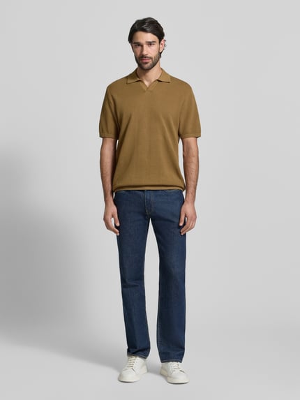 Männermodel trägt Regular Fit Poloshirt mit gerippten Abschlüssen von MCNEAL in Braun, kombiniert mit blauer Jeans, Ganzkörperansicht von vorne. Herren Poloshirt aus reiner Baumwolle mit Polokragen, Rückenlänge 71 cm, Ärmellänge 30 cm.