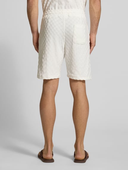 Männermodel trägt Regular Fit Shorts mit Label-Patch von Lindbergh in Weiß, Baumwoll-Mix, strukturierte Oberfläche, Ganzkörperansicht Rückansicht.