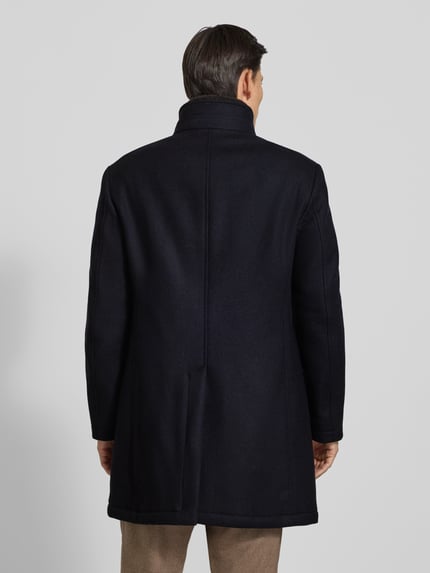 Männermodel trägt Regular Fit Wollmantel aus Woll-Mix mit herausnehmbarem Stepp-Inlay von JOOP! COLLECTION in Dunkelblau, Ganzkörperansicht Rückansicht.
