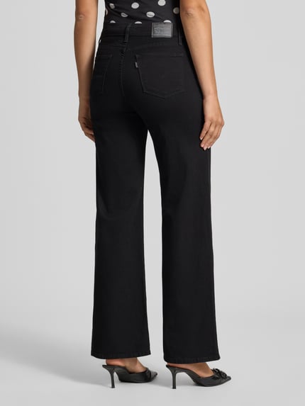 Vrouwenmodel draagt Wide Leg Jeans aus Baumwoll-Mix Modell '318' van Levi's® 300, zwarte kleur, effen textuur, Ganzkörperansicht Rückansicht.