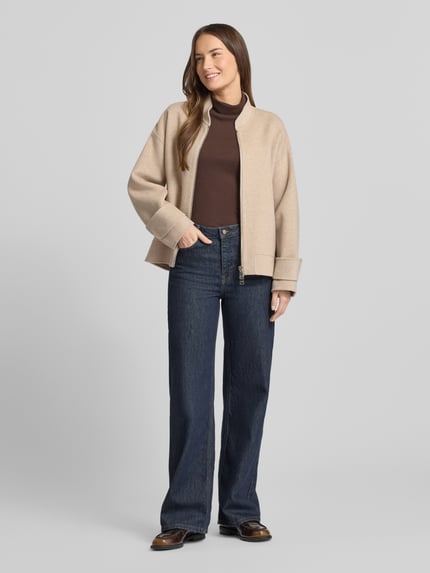 Frauenmodel trägt Regular Fit Jacke aus reiner Schurwolle von Windsor in Beige, mit Stehkragen, Zweiwege-Reißverschluss, Ganzkörperansicht von vorne.