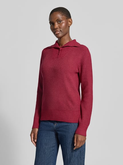 Frauenmodel trägt Sim Fit Pullover aus Viskose-Mix von Christian Berg Woman in Strick-Optik, dunkles Rot, Troyer-Kragen, Ganzkörperansicht von vorne.