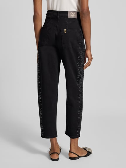 Frauenmodel trägt Jeans aus Baumwoll-Mix mit Strasssteinbesatz von Liu Jo White, lockere Passform, schwarze Textur, Ganzkörperansicht Rückansicht.