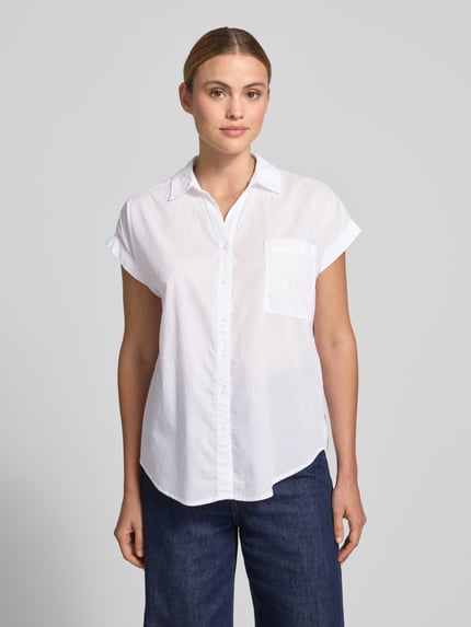 Frauenmodel trägt Relaxed Fit Bluse mit Brusttasche Modell 'DORA' von Soyaconcept aus Reiner Baumwolle, weiß, Hemdblusenkragen, Kappärmel, Ganzkörperansicht von vorne.