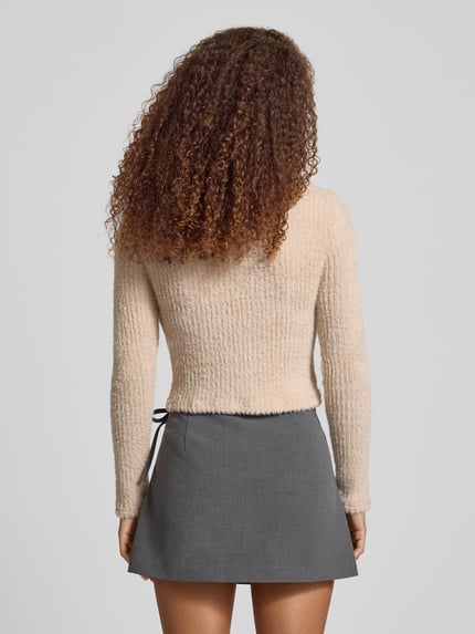 Frauenmodel trägt Slim Fit Strickpullover Modell 'VIOLA' von Only in Unifarben mit Label-Stitching, Rundhals, Langarm, Strick, Ganzkörperansicht Rückansicht.