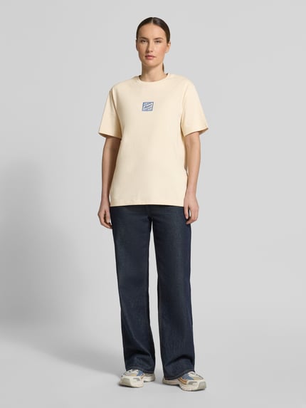 Frauenmodel trägt Damen T-Shirt Relaxed Fit T-Shirt aus reiner Baumwolle Modell 'BROOK SS HOTEL' von Selected Femme, Optik: Unifarben, Passform: Relaxed-Fit, Label-Stitching-Applikation, Rundhals-Ausschnitt, Ärmelform: Kurzarm, Materialverarbeitung: Jersey, Material: Reine Baumwolle, sanfte Beige-Töne, glatte Textur, Ganzkörperansicht von vorne.