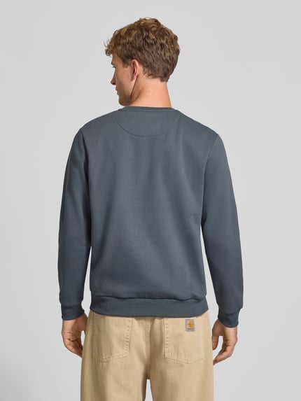 Männermodel trägt Regular Fit Sweatshirt mit Baumwoll-Anteil Modell 'Bradley' von JACK & JONES, einfarbig grau, Rückenansicht, Ganzkörperansicht Rückansicht. Material-Mix, gerippte Abschlüsse, Rundhalsausschnitt.