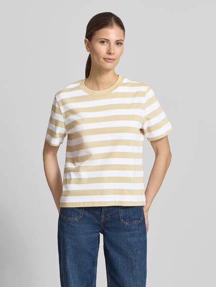 Frauenmodel trägt Boxy Fit T-Shirt aus reiner Baumwolle Modell 'ESSENTIAL' von Selected Femme mit beige-weißem Streifenmuster, heavy Jersey, Ganzkörperansicht von vorne.