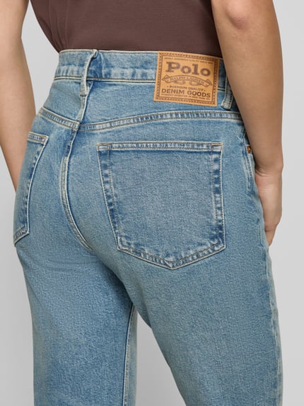 Kobieta nosi Skinny Fit Jeans z wpuszczanymi kieszeniami od Polo Ralph Lauren, mieszanka bawełny i elastanu, efekt znoszenia, detal tylnej kieszeni, zbliżenie tyłu.