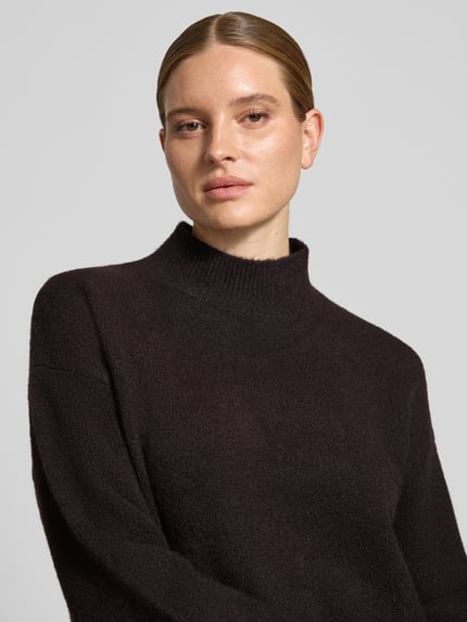Frauenmodel trägt Turtleneck-Pullover mit Woll-Anteil und Rundhalsausschnitt von Neo Noir in dunkler Farbe, Struktur fein gestrickt, Nahaufnahme Oberkörper.