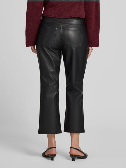 Frauenmodel trägt Flared Fit Hose in -Optik von Christian Berg Woman, schwarze Farbe, elastischer Bund, verkürzte Passform, Ganzkörperansicht Rückansicht.