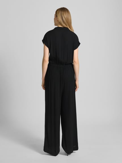 Frauenmodel trägt Jumpsuit aus Viskose mit V-Ausschnitt Modell 'MARRAKECH' von ICHI in Schwarz, tailliert, Ganzkörperansicht Rückansicht.