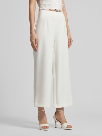 Frauenmodel trägt Straight Fit Stoffhose mit Viskose-Anteil Modell 'Leonie' von GUIDO MARIA KRETSCHMER WOMAN, weiß, Ziernähte, weites Bein, Elastischer-Material-Mix, Ganzkörperansicht von vorne.