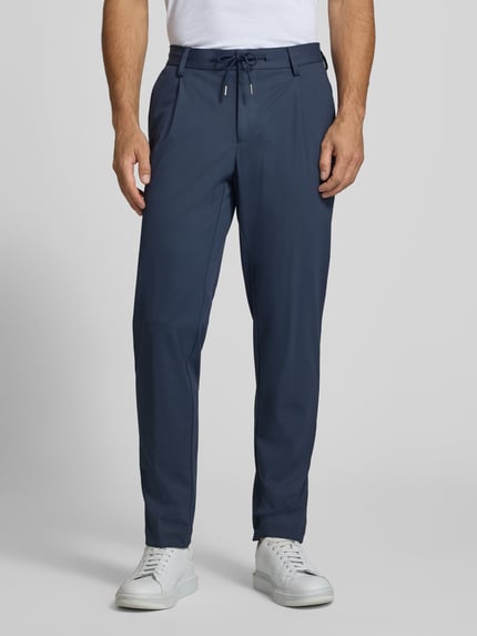 Männermodel trägt Regular Fit Hose mit Tunnelzug und Eingrifftaschen von bugatti, Material-Mix mit Stretch, Ganzkörperansicht von vorne.