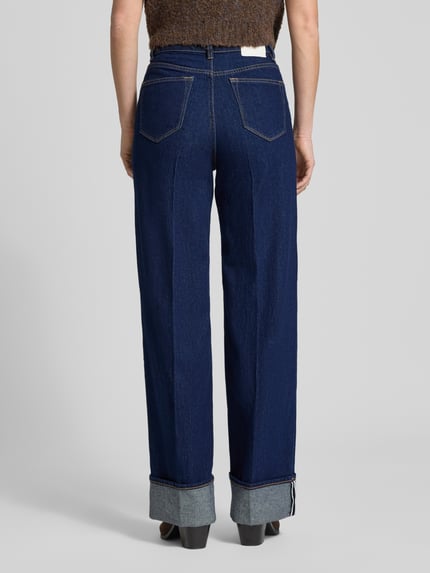 Kobiece model prezentuje Regular Fit Wide Leg Jeans aus Baumwoll-Mix von Tom Tailor Denim, ciemnoniebieski denim, wysokie talia, detal label patch, pięć kieszeni, szerokie nogawki, tekstura bawełny, krój regular fit, szwy kontrastowe, widok całej sylwetki od tyłu
