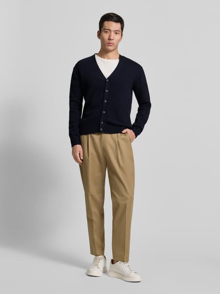 Männermodel trägt Strickjacke mit Knopfleiste Modell 'KARL' von Casual Friday, dunkelblau, Slim Fit, Baumwoll-Mix, Ganzkörperansicht von vorne.