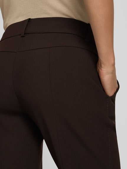 Kobiece modelka nosi Regular Fit Schmale Hose mit Viskose-Baumwoll-Anteil Modell 'FARAH' von CAMBIO, spodnie damskie, ciemnobrązowy kolor, gładka tekstura, detal tyłu, zbliżenie na biodro.