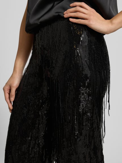 Männermodel trägt Stoffhose mit Paillettenbesatz von Milano Italy, czarny kolor, luźny krój, elastyczny pas, zbliżenie na biodra, Nahaufnahme Oberkörper.