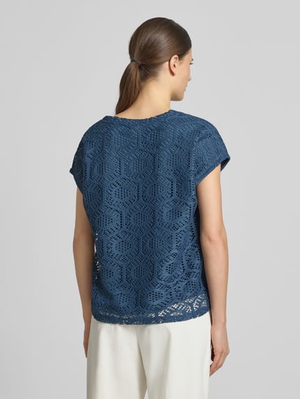 Männermodel trägt Boxy Fit T-Shirt mit semitransparentem besatz Modell 'IRIS' von Vero Moda, damski t-shirt, efekt: jednolity kolor, krój: pudełkowy krój, wzór: abstrakt, półprzezroczysty materiał, dekolt w serek, bez rękawów, wykończenie materiału: ażur, stretch, Ganzkörperansicht Rückansicht