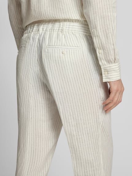 Männermodel trägt Leinenhose mit Bügelfalten und Eingrifftaschen von JAKE*S STUDIO MEN, cremefarbenes Streifenmuster, Ganzkörperansicht Rückansicht.
