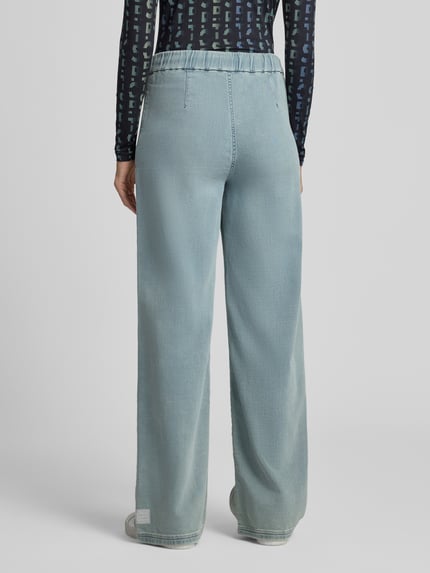 Frauenmodel trägt Wide Fit Jeans aus Baumwoll-Mix von Marc Cain, elastischer Bund, Eingrifftaschen, hellblaue Farbe, Ganzkörperansicht Rückansicht.