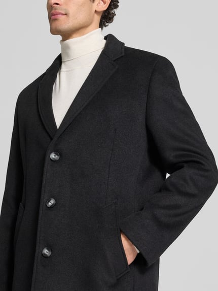 Męski model nosi Regular Fit Mantel im 2-in-1-Look od bugatti, Mieszanka wełny, czarny, Kołnierz z połami, Listwa guzikowa, Wpuszczane kieszenie, Długość tyłu w rozmiarze 50: 93 cm, Szerokość ramion w rozmiarze 50: 45 cm, Szerokość w rozmiarze 50: 55 cm, Długość rękawów: 68 cm, zbliżenie na górną część tułowia