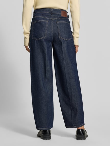 Frauenmodel trägt Relaxed Fit Jeans aus reiner Baumwolle von MYON, dunkles Denim, Kontrastnähte, 5-Pocket-Design, Bundweite 38 cm, Ganzkörperansicht Rückansicht.