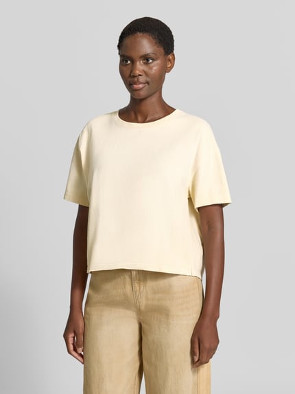 Vrouwenmodel draagt t-shirt met ronde hals Model 'AFOMA' van American Vintage, puur katoen, boxy fit, ruglengte maat XS/S 52 cm, vooraanzicht volledige lichaamsopname.