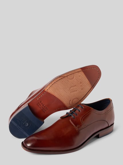 Produktfoto, Derby aus Leder mit Schnürung Modell 'Milko' von Bugatti in Braun, mit abgerundete Spitze, Label-Detail, Absatzhöhe 2 cm, Schafthöhe 7 cm, Schaftweite 11 cm, glatte Textur.