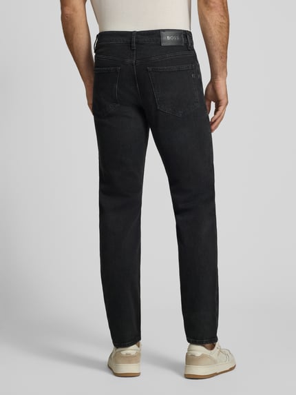 Männermodel trägt Straight Fit Jeans aus Baumwoll-Mix Modell 'Ogden' von BOSS in dunklem Grau, strukturierte Oberfläche, Ganzkörperansicht Rückansicht, Herren Slim Fit Jeans von BOSS.