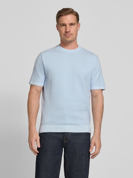 Męski model nosi T-Shirt z label-Detail model 'MILANO' od Jack & Jones Premium z bawełnianej mieszanki, prosty krój, okrągły dekolt, jasnoniebieski kolor, gładka faktura, długość tyłu w rozmiarze M: 70 cm, widok całej sylwetki z przodu.