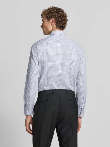Männermodel trägt Slim Fit Businesshemd aus reiner Baumwolle Modell 'New B.D.' von Seidensticker, feines Karo-Muster, Ganzkörperansicht Rückansicht, Herren Businesshemd von Seidensticker.