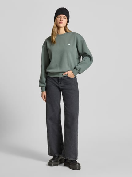 Vrouwenmodel draagt sweatshirt met labelstitching model 'CASEY' van Carhartt Work In Progress in puur katoen, relaxed fit, ronde hals, voorkant volledig lichaam.