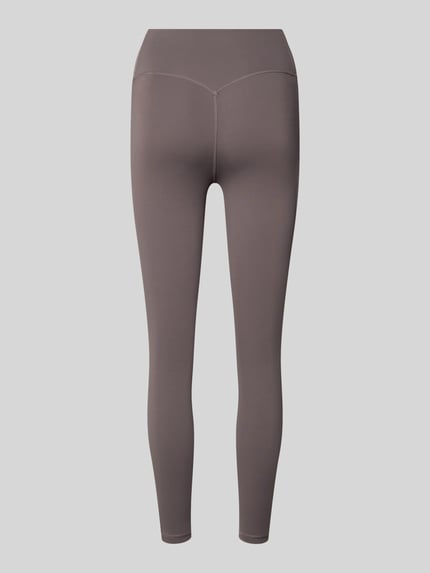 Frauenmodel trägt Leggings mit Label-Print von adidas Sportswear in Taupe, körpernaher Schnitt, elastischer Bund, Rückansicht Ganzkörperansicht.
