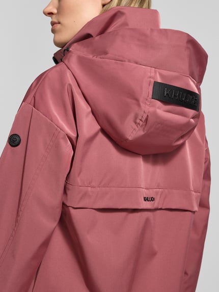 Vrouwenmodel draagt Jacke mit Stehkragen van khujo in roze met opstaande kraag, ritssluiting, ritszakken, regular fit, ruglengte maat S 60 cm, schouderbreedte 51 cm, borstwijdte 50 cm, mouwlengte 54 cm. Detailopname rugaanzicht.