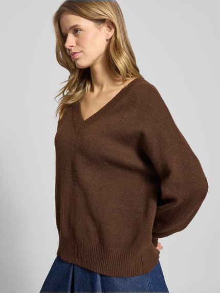 Frauenmodel trägt Regular Fit Strickpullover mit Woll-Anteil Modell 'MARI' von Only in brauner Melange-Optik, V-Ausschnitt, Langarm, gerippter Ärmel- und Rumpfabschluss, Strick-Material, Nahaufnahme Oberkörper.