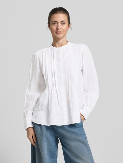 Frauenmodel trägt Regular Fit Langarmbluse aus reinem Leinen von Marc O’Polo, weiß, unifarben, Tunika-Kragen, Nahaufnahme Oberkörper.