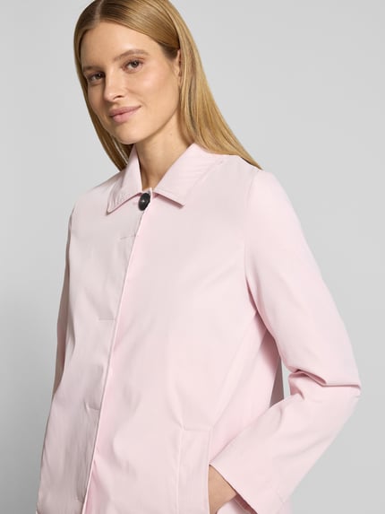 Kobiece modelka nosi Mantel mit verdeckter Knopfleiste und Eingrifftaschen von Christian Berg Woman Selection w jasnoróżowym kolorze, prosta forma, kent kołnierzyk, ukryte zapięcie na guziki, boczne kieszenie, długość tyłu w rozmiarze 36: 87 cm, szerokość ramion w rozmiarze 36: 40 cm, szerokość klatki piersiowej w rozmiarze 36: 54 cm, długość rękawa w rozmiarze 36: 62 cm, półzbliżenie od przodu.